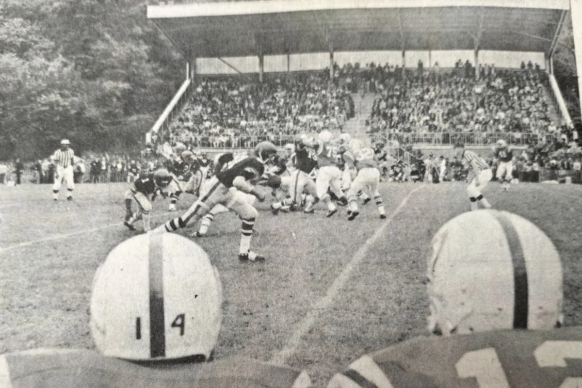 Two Alconbury players (helmets to camera) look across the pitch to the Sardis Road grandstand with the Upper Heyford Skykings in possession. Pic: Paul Rose.
